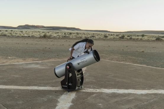 Local astro guide Amy-Lee Visagie peers through a telescope during the early evening. Image: Ihsaan Haffejee, GroundUp